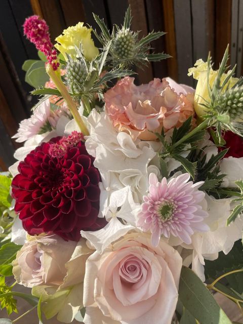 Bouquet aux dahlias grenat, roses poudrées, lisianthus et chardons